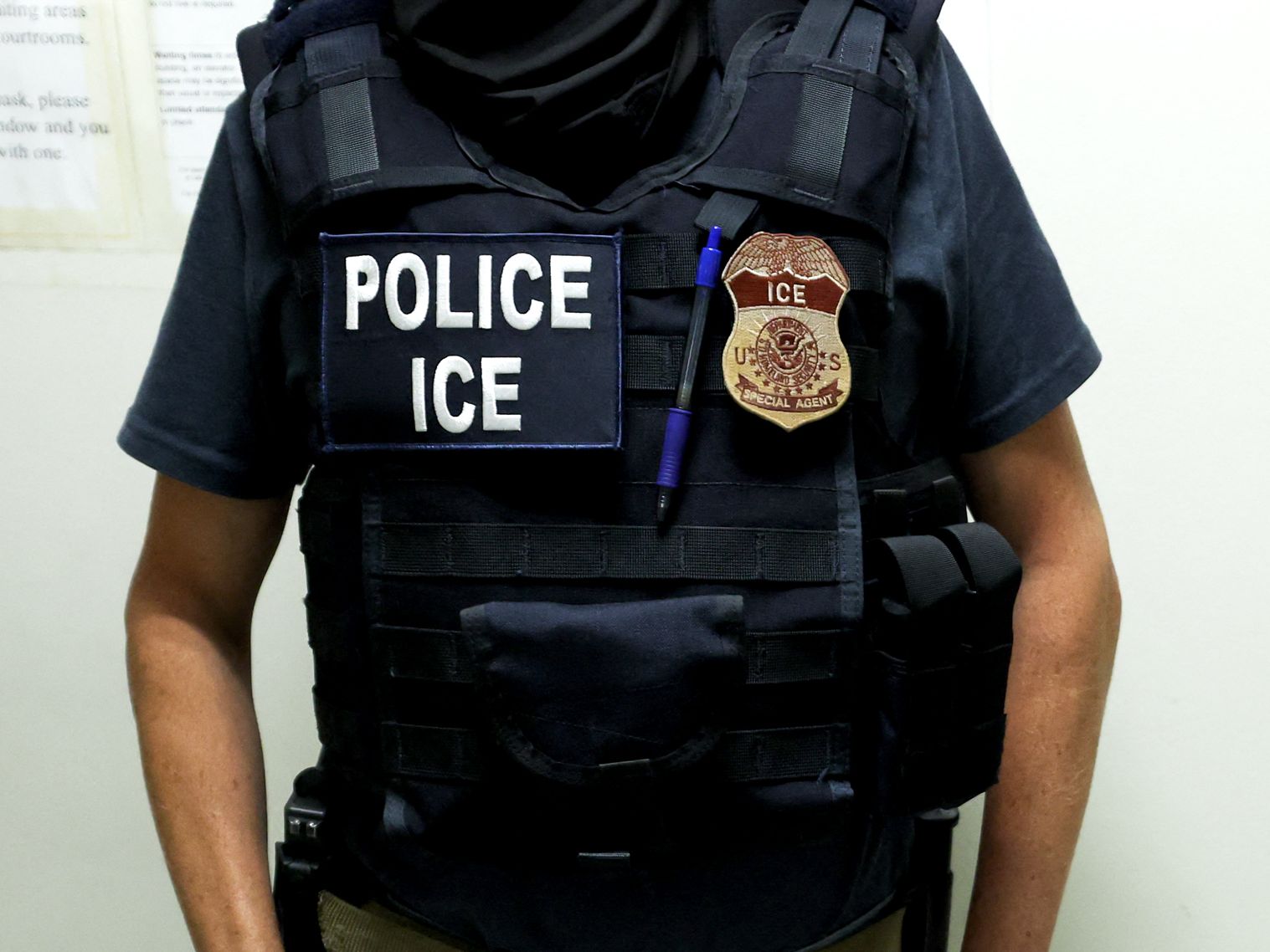 An agent of Immigration and Customs Enforcement  waits in a hallway outside of a courtroom at New York Federal Plaza...